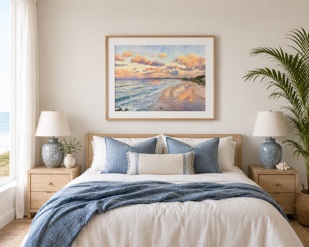 Framed Currumbin Beach watercolour print displayed above a bed in a coastal-style bedroom