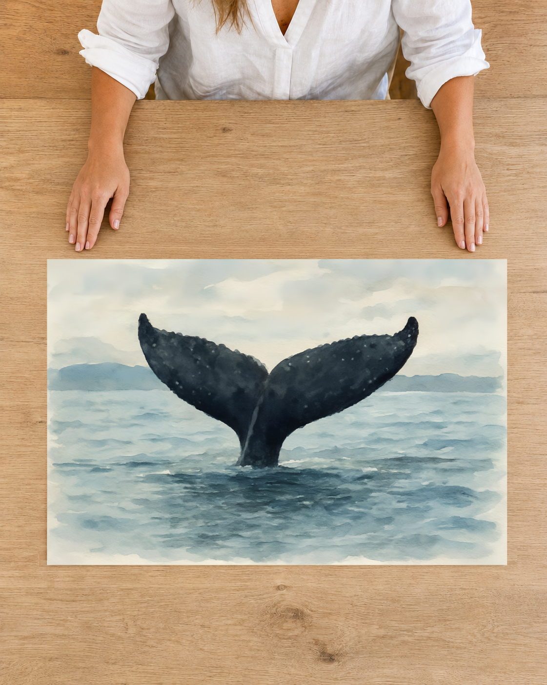 Overhead view of an unframed whale tail fine art print on premium matte paper